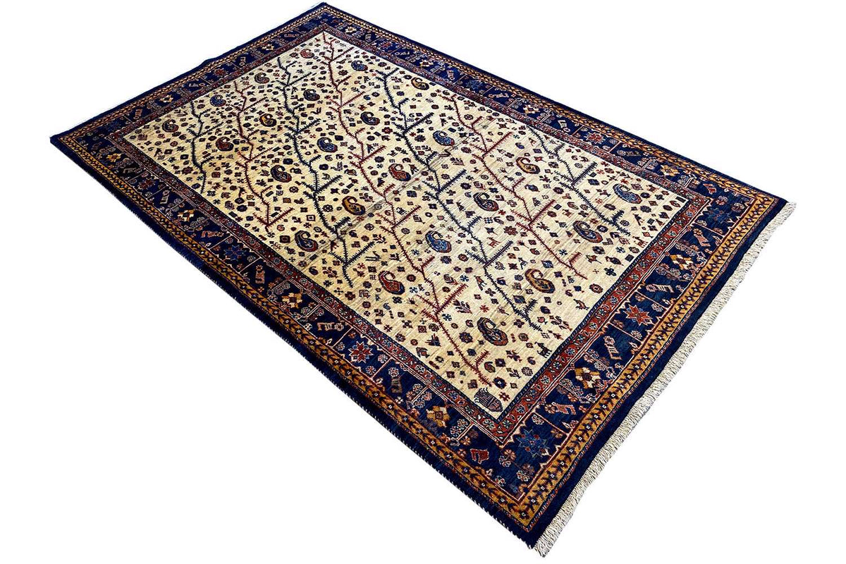 Qashqai rug with a blue border and medallion and vine patterns on a light background