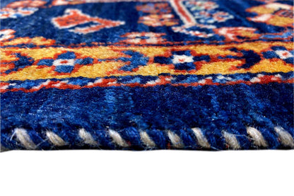 Rug fringe along the blue edge, textured wool with colorful ornamental bands