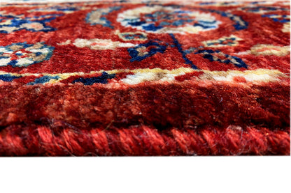 Close-up: red pile with colorful patterned stripes and a soft textile surface