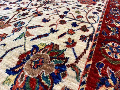 Detailed view: cream-colored carpet with blue-red floral ornaments and a red border