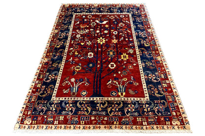 Oriental rug, red field with tree and animal motifs, blue-and-white border