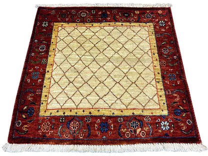 Square rug with a red border design, beige center, and fringe