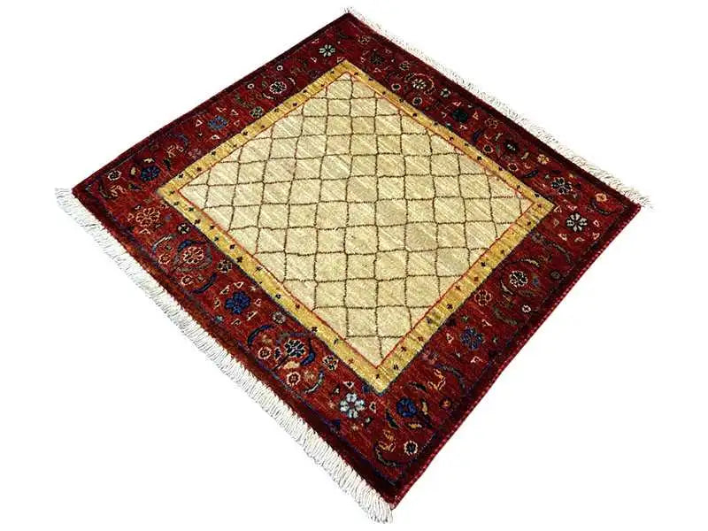 Square rug with a beige diamond pattern in the center and a red border