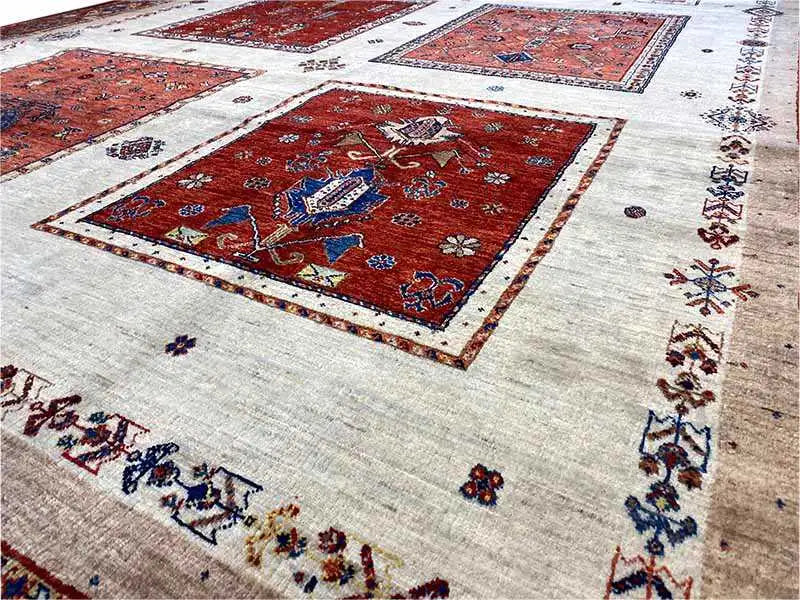 Rug detail with a large red square pattern on a light, patterned background