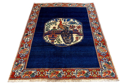 Blue rug 178x143 cm with a central animal motif and colorful border frame