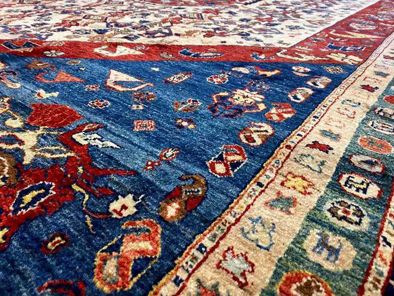 Oriental rug detail with blue motifs, red accents, and a light decorative border