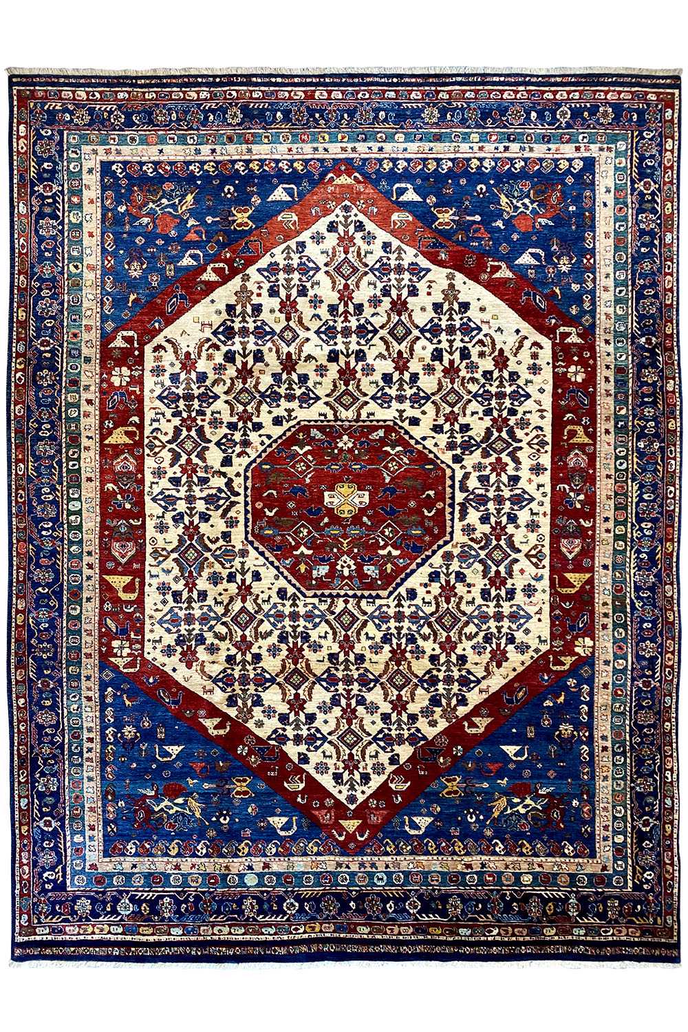 Oriental rug with a blue background, multicolored diamond pattern, and red medallion