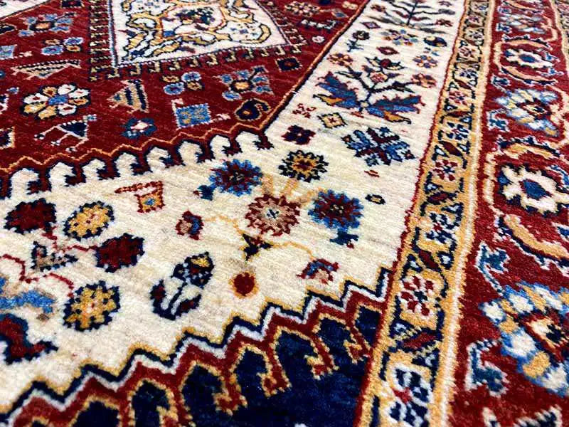 Detail of the runner rug: floral ornaments in red, blue, and cream on a light background