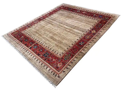 Beige oriental rug with a red border and decorative embellishments at the corners