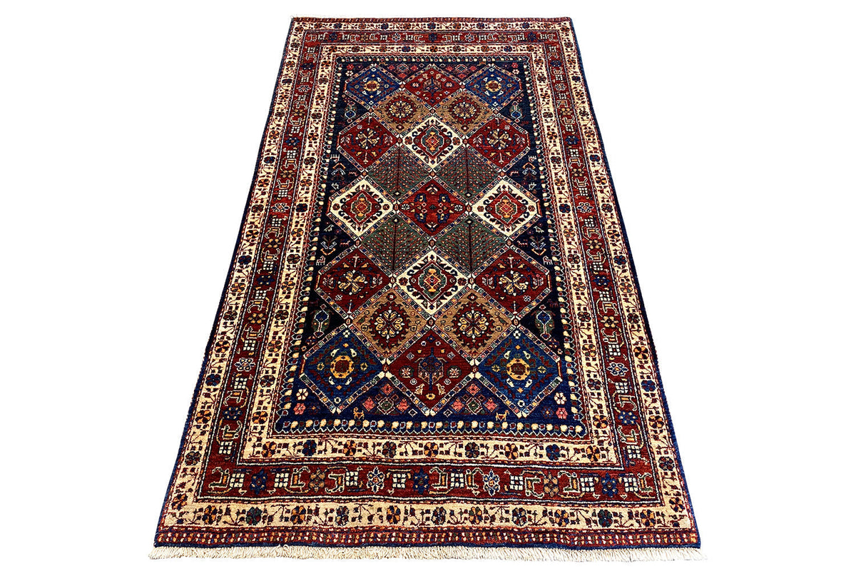 Large Oriental rug with diamond medallion, red-and-blue ornamentation, and framed border pattern