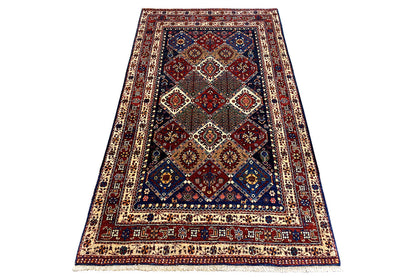 Large Oriental rug with diamond medallion, red-and-blue ornamentation, and framed border pattern