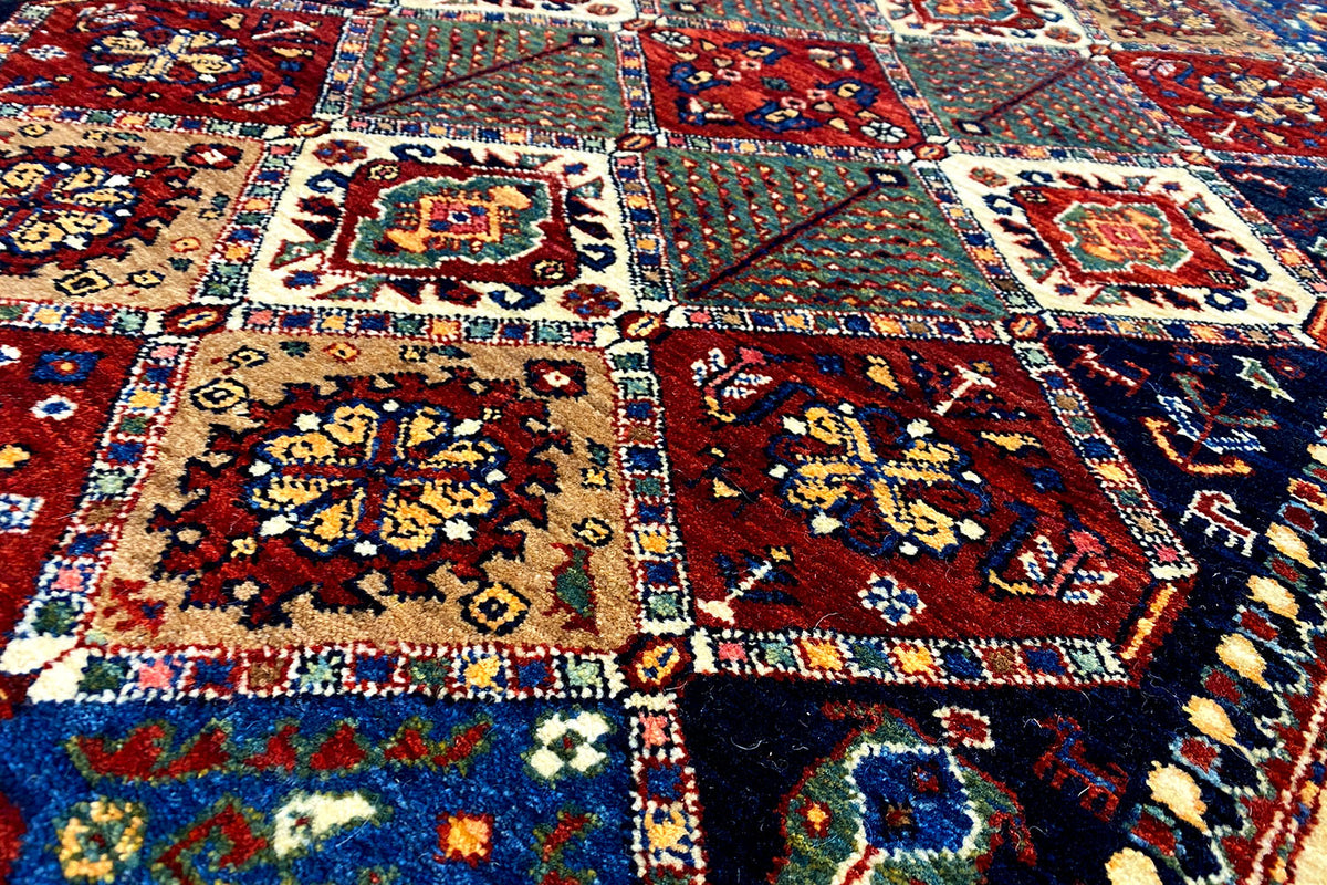 Oriental rug surface with detailed ornamental fields in red, blue, cream, and green