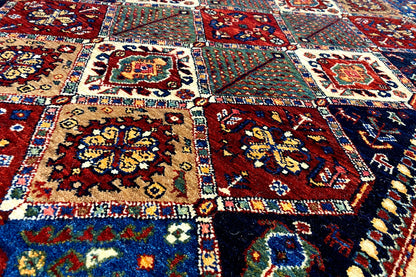 Oriental rug surface with detailed ornamental fields in red, blue, cream, and green
