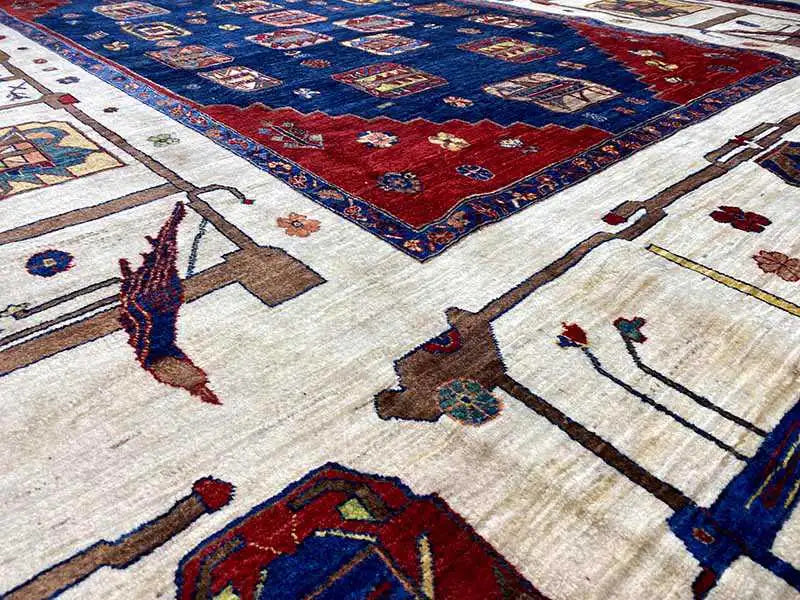 Close-up of an oriental rug with red, blue, and cream-colored motifs, detailed contours