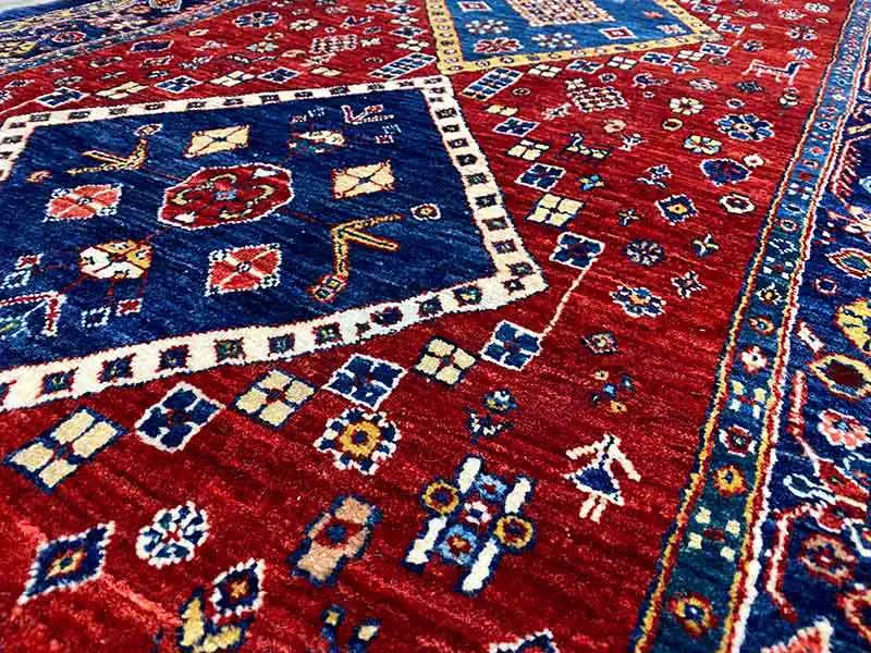 Close-up of the carpet pattern: red background, dark blue ornaments, and small motifs