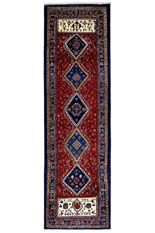 Narrow Oriental runner rug with a red field, dark blue border, and diamond motifs