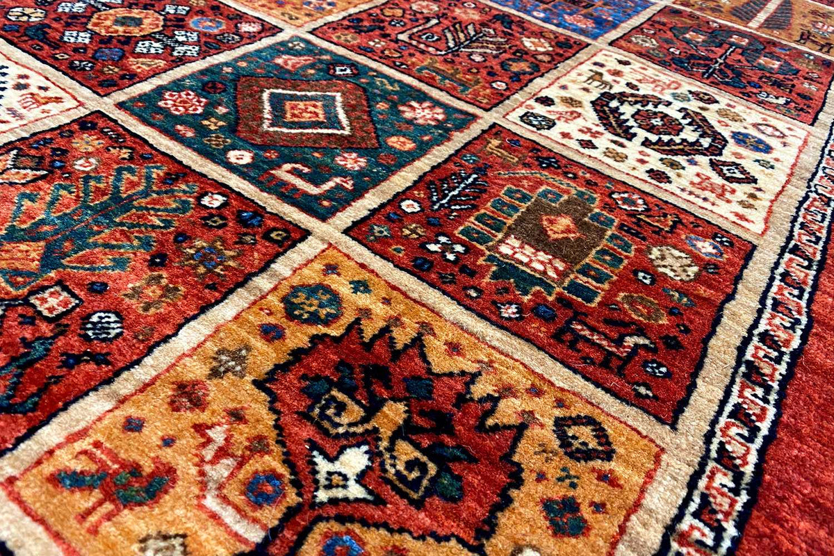 Qashqai exclusive runner rug, close-up: multicolored geometric ornaments on red