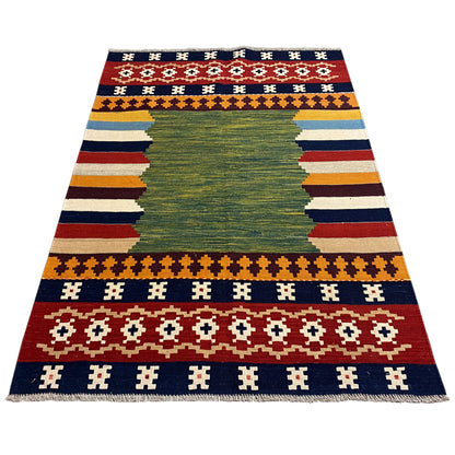 Flat-laid kilim rug with a green central motif and stripes in blue, red, and yellow