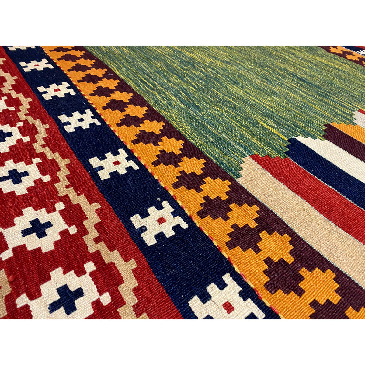 Close-up: Kilim pattern with zigzags in red, blue, and beige, as well as a green central area