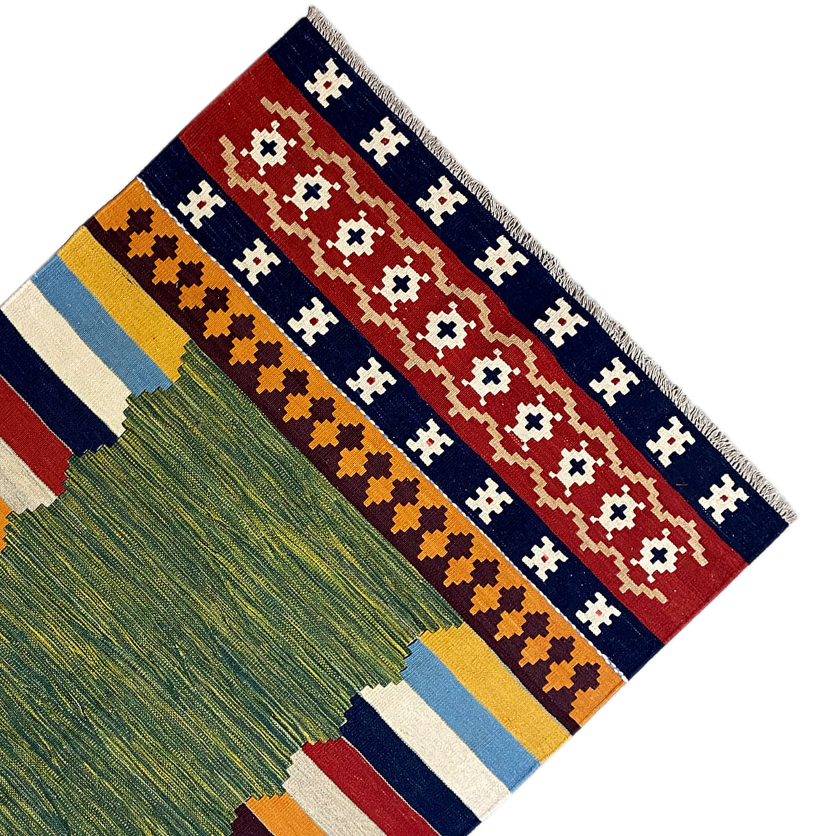 Kilim rug corner with fringe and patterned stripes in green, red, and blue