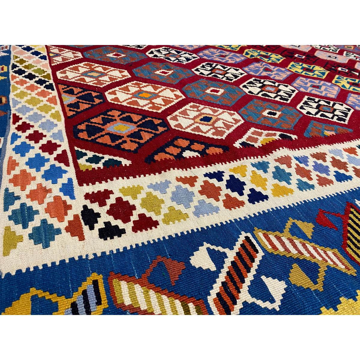 Close-up of a kilim rug: multicolored geometric motifs with diamonds, bars, and ornaments