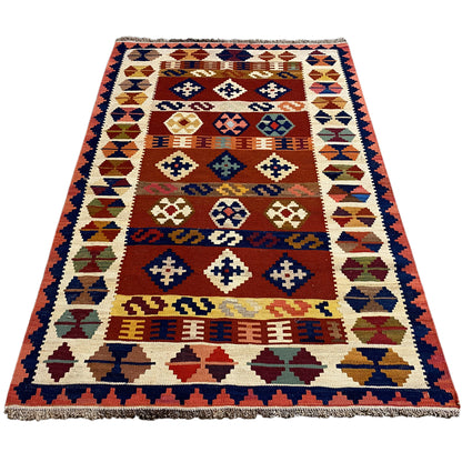 Rectangular kilim rug with geometric motifs and fringes along the edge.