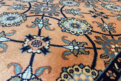 Close-up: floral-patterned ornaments in orange, blue, and beige on a carpet background