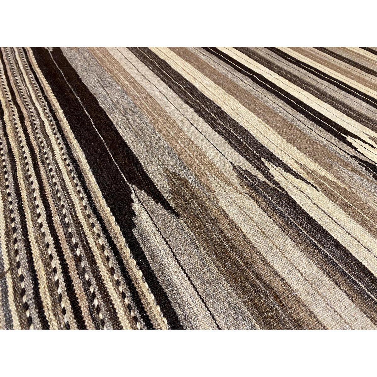 Close-up: rug with a high-contrast striped pattern and decorative border