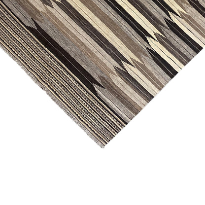 Carpet corner with fringes and border, striped pattern in gray, beige, and dark brown