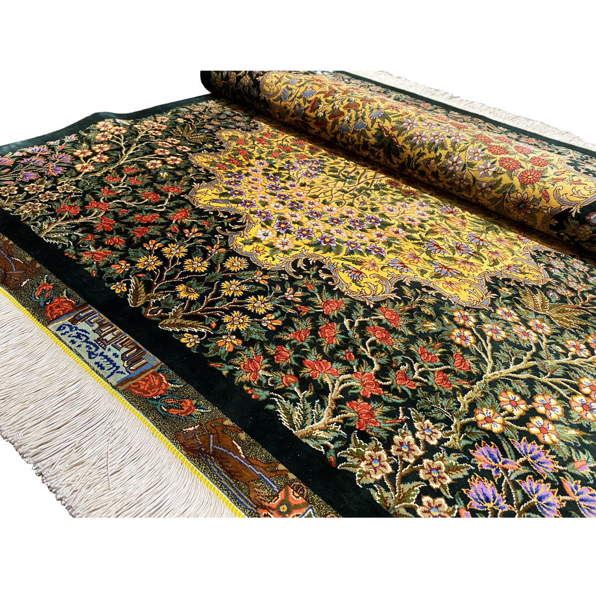 Silk rug with a floral pattern on a dark background, folded, with a fringed edge