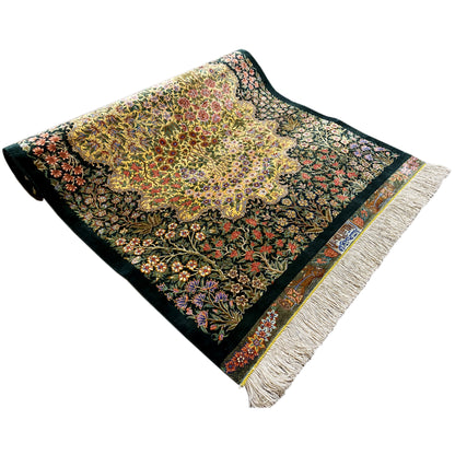 Square silk rug with fringes, a dark background, and a colorful floral pattern