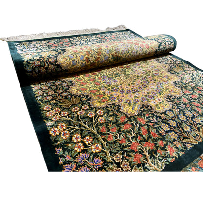 Silk rug with a dark background and lush floral pattern, rolled with fringes