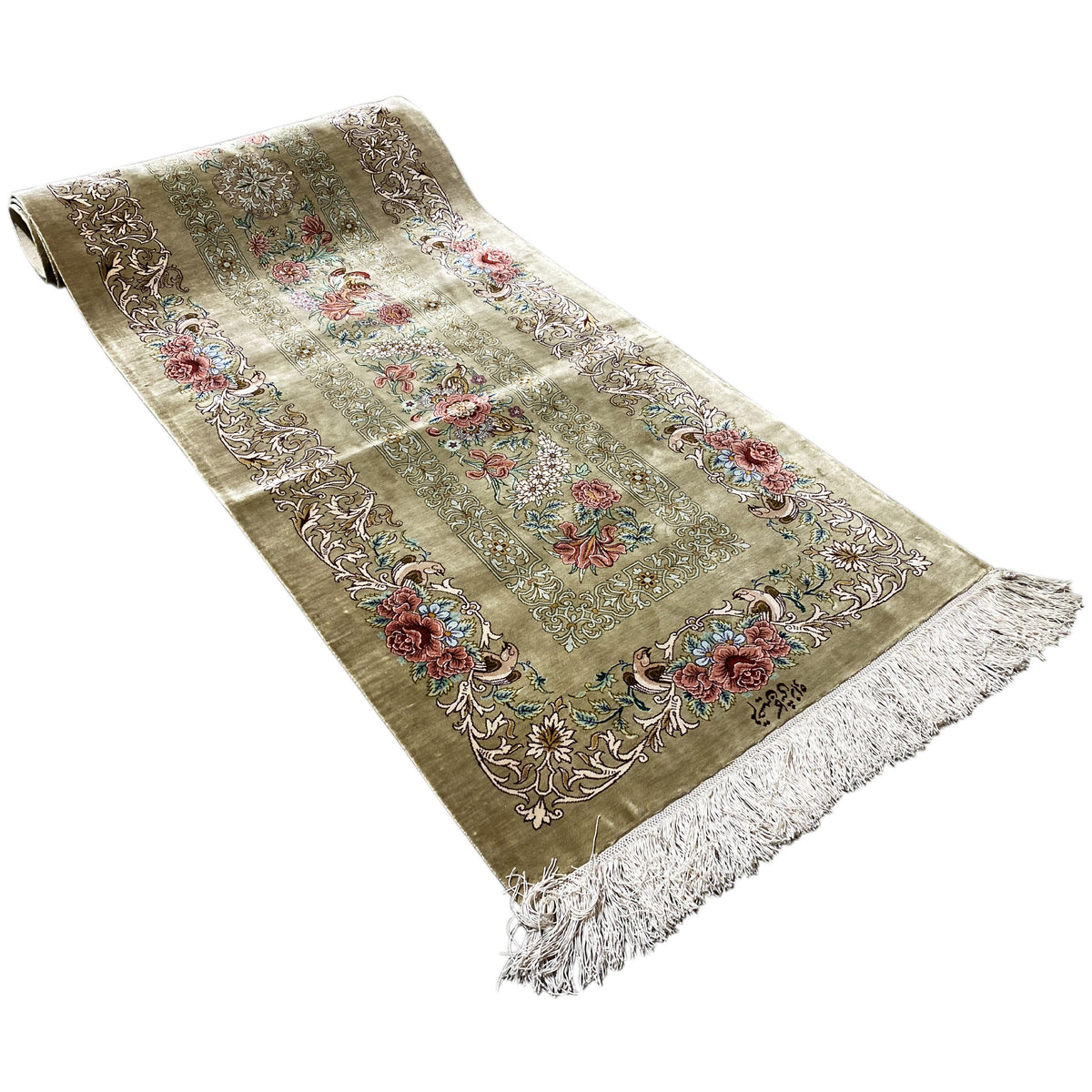 Rolled-up silk carpet in view: floral pattern, olive-brown background, side fringes