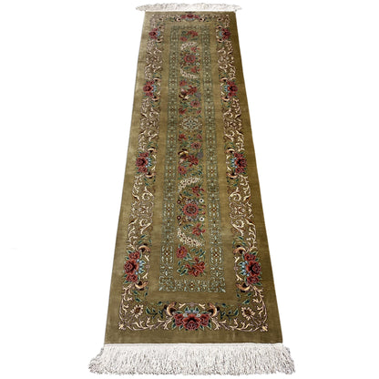 Silk runner rug with a light border pattern, colorful floral ornaments, and fringes at the bottom