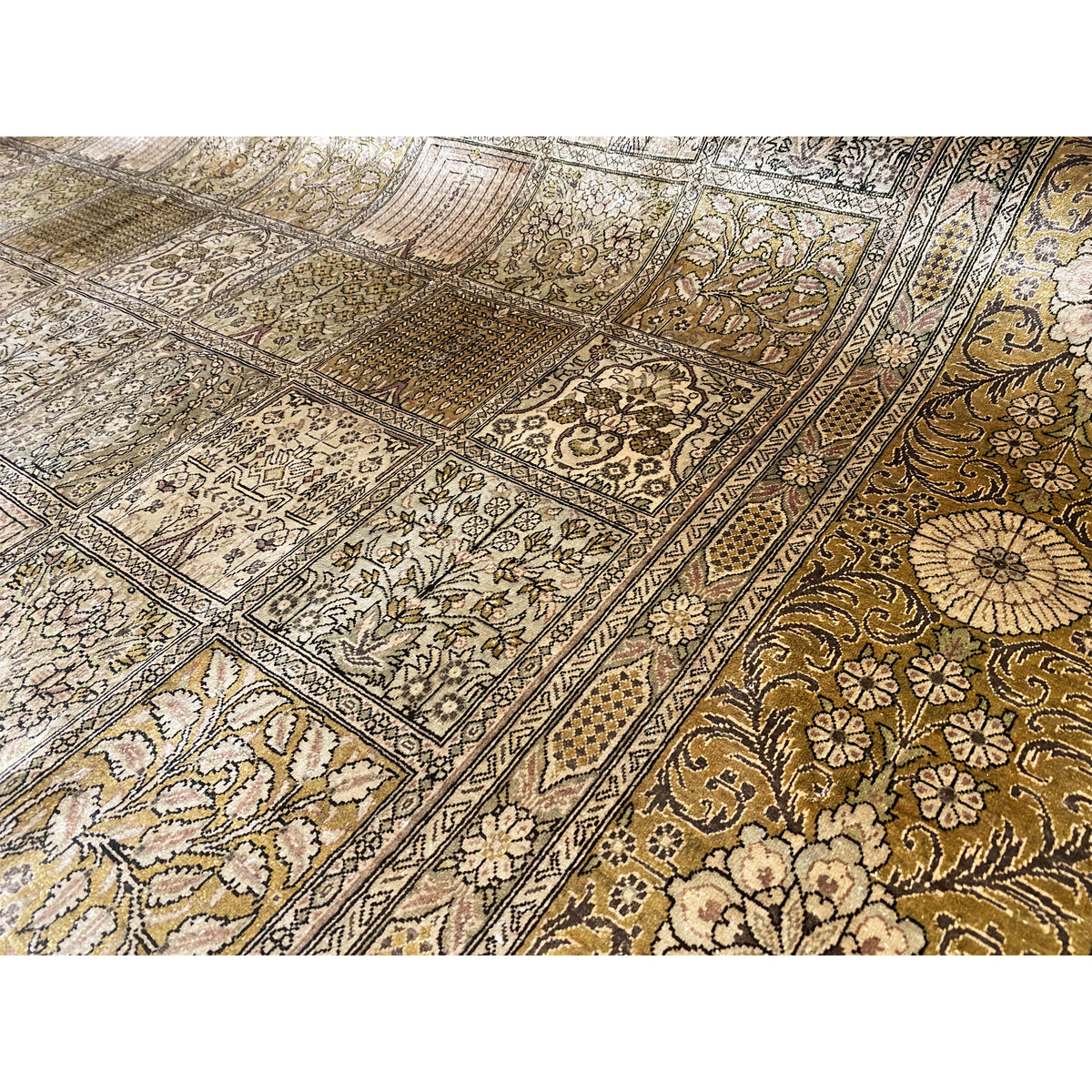 Close-up: Ghom rug with an ornamental patchwork pattern in beige, brown, and gold