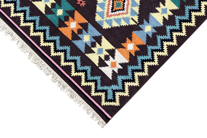 Rug corner with zigzag and triangular patterns, colorful accents, and fringes