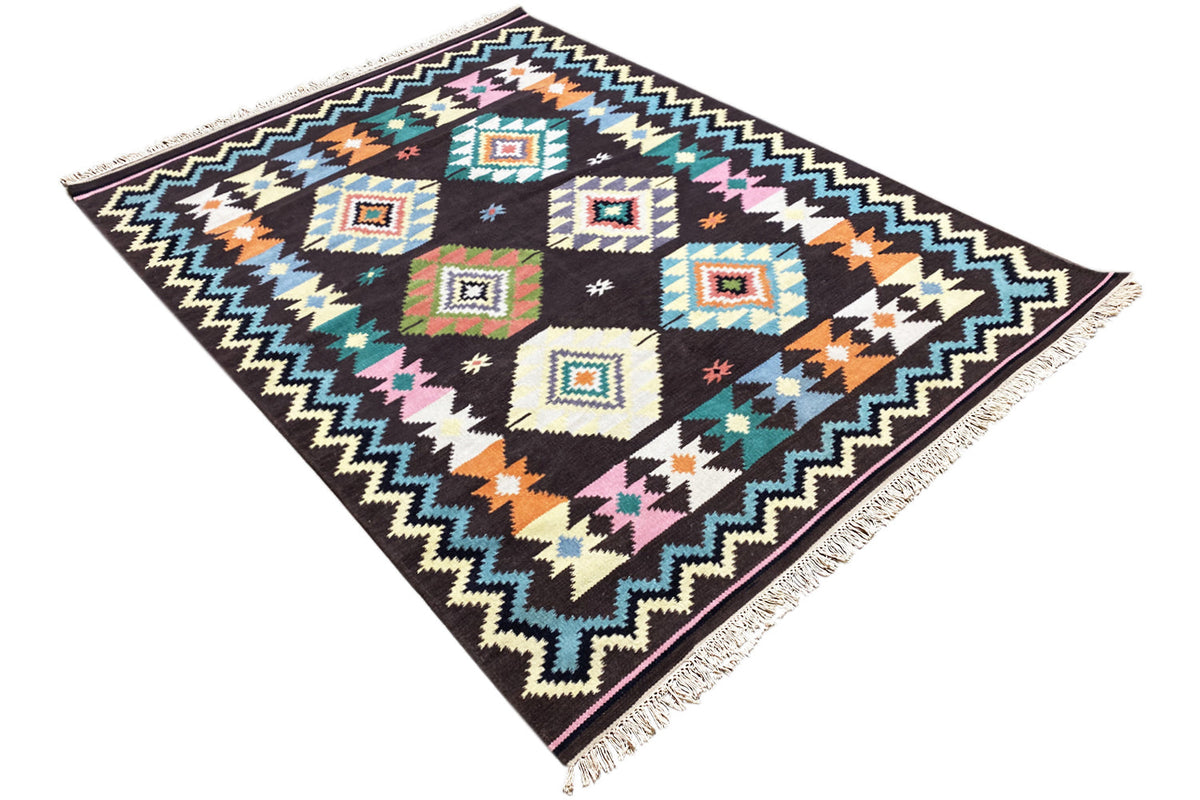 Wool rug with geometric cube and zigzag patterns, bright colors, and fringes