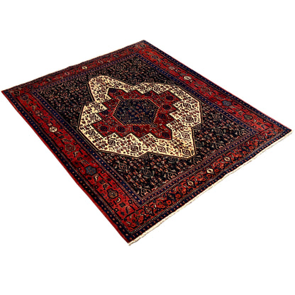 Dark blue carpet with a red border and beige ornamental medallion, photographed diagonally.