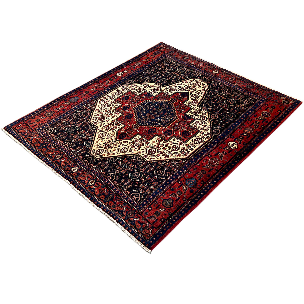 Rectangular rug with a dark pattern, red outer border, and beige central ornamentation.