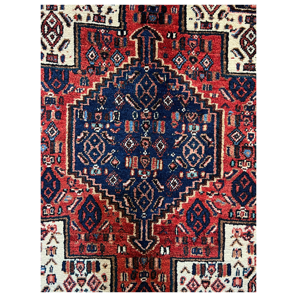 Carpet detail: geometric ornaments in dark blue, red, and beige arranged in a square pattern.
