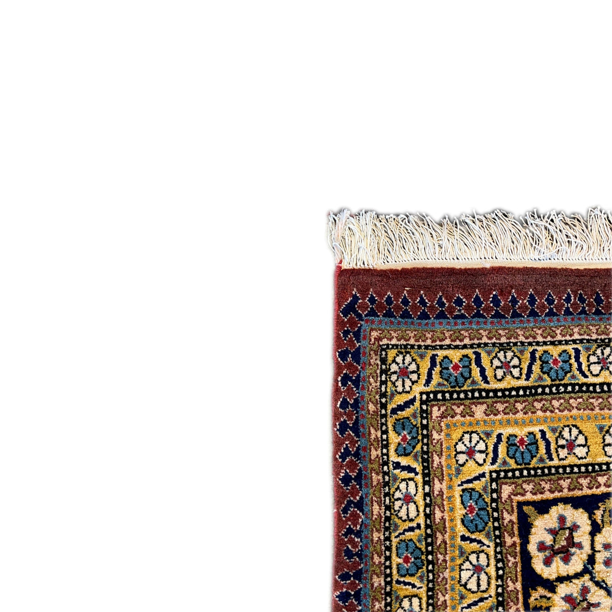 Shahreza carpet detail: fringes at the edge and a blue-and-gold ornamental border with a red field