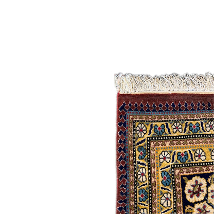 Shahreza carpet detail: fringes at the edge and a blue-and-gold ornamental border with a red field