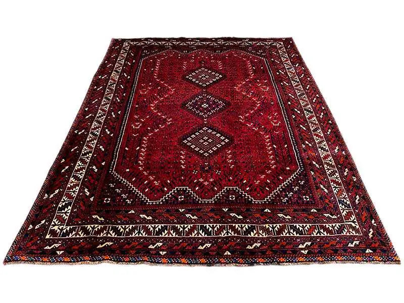 Red carpet with central ornaments, multicolored border, and geometric motifs