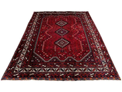 Red carpet with central ornaments, multicolored border, and geometric motifs