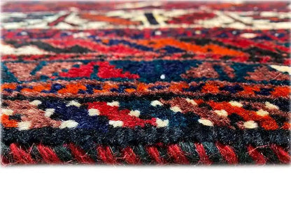 Rug edge with short fringes and a red gradient, dense multicolored pattern