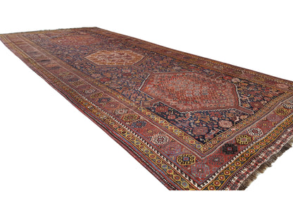 Oriental rug with borders and geometric motifs in rust red, blue, and yellow, 455x194 cm