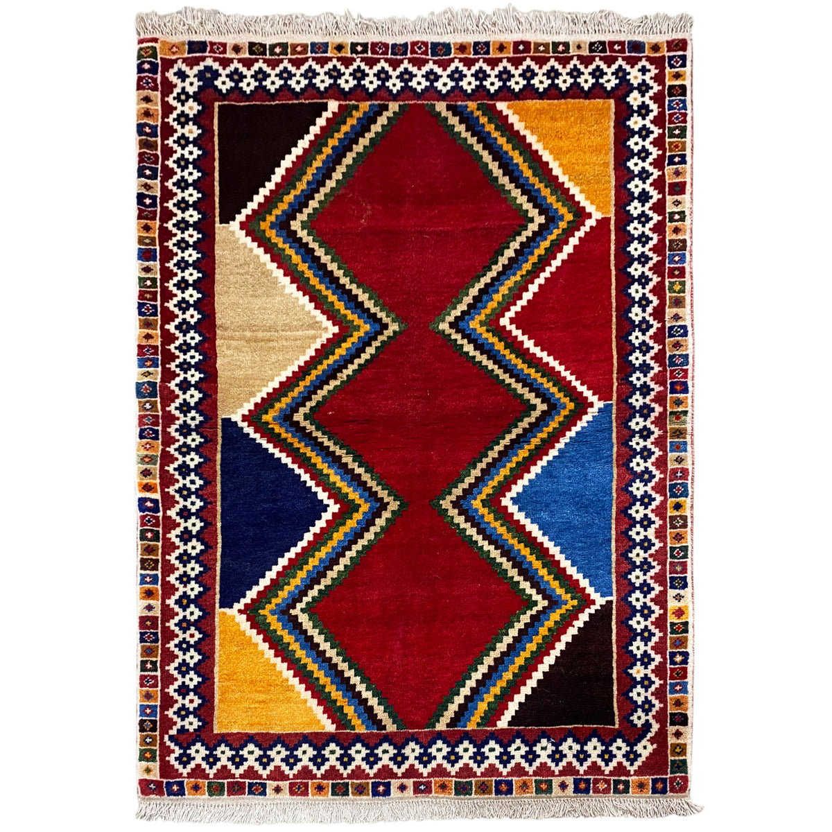 Shiraz rug with a geometric diamond design in red, blue and beige, rectangular, with fringes.