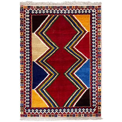 Shiraz rug with a geometric diamond design in red, blue and beige, rectangular, with fringes.