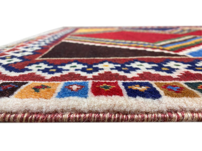 Close-up: border of a Shiraz rug with ornamental stripes in blue, red, and beige, short pile height.