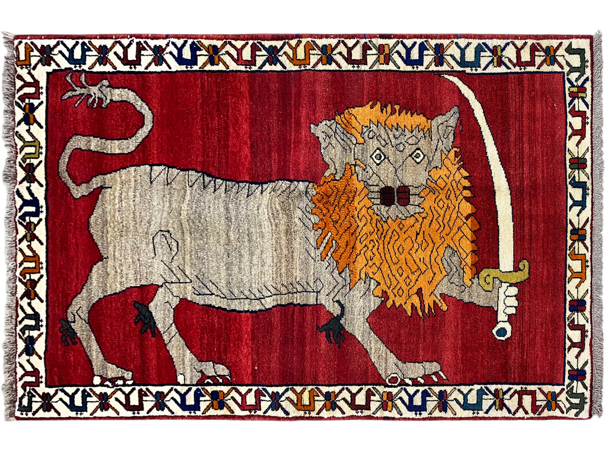 Rug with a red geometric pattern and animal design in gray, orange, and yellow